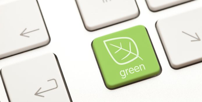 Close-up of a keyboard with a green key featuring a leaf icon and the word 'green,' symbolizing eco-friendly technology.